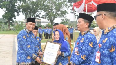 Sekda Merangin Ir Fajarman menyerahkan piagam penghargaan kepada Kepala BPPRD Hj. Siti Aminah di halaman depan kantor bupati Merangin. Senin (19/2/2024).