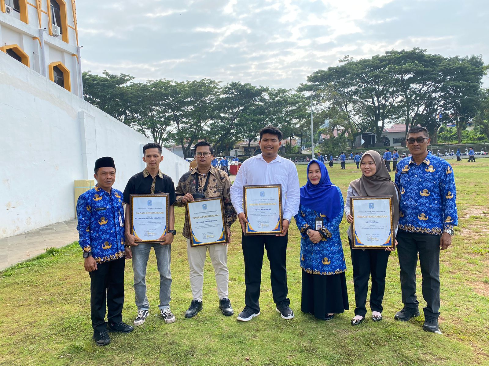 Kepala BPPRD Merangin Hj. Siti Aminah menyerahkan piagam penghargaan wajib pajak daerah kepada pihak swasta dihalaman kantor bupati Merangin. 